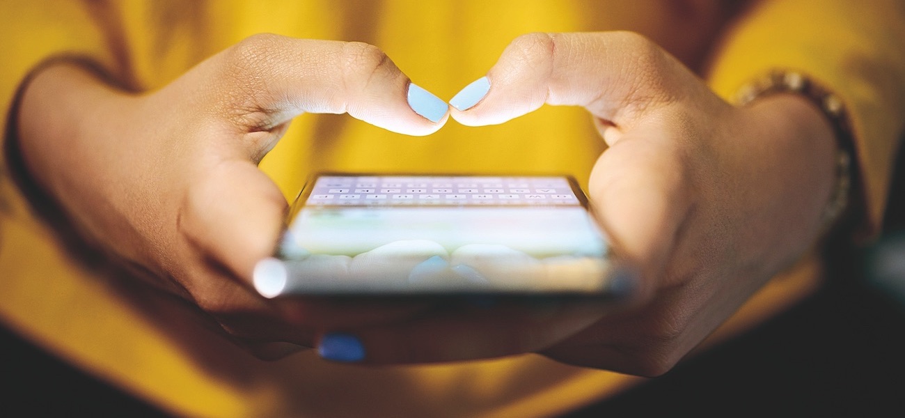 Woman Typing Phone Message On Social Network At Night